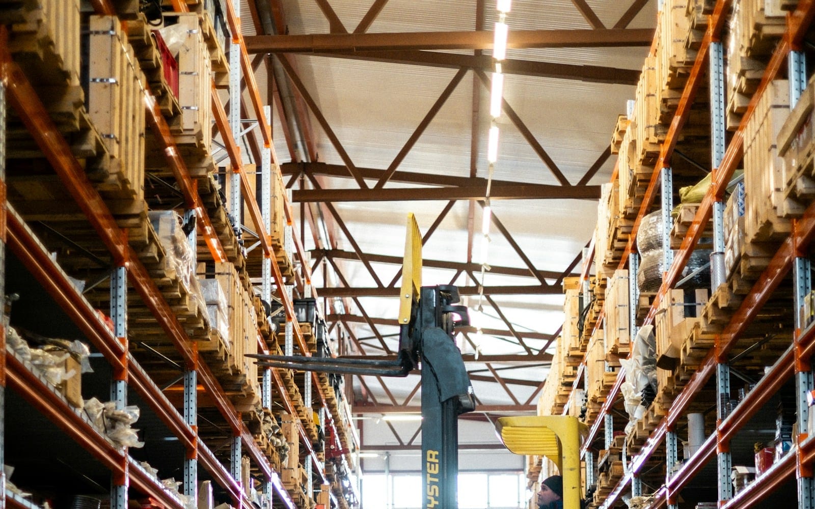Forklift moving stock in a large warehouse — a typical host environment for labour hire placements